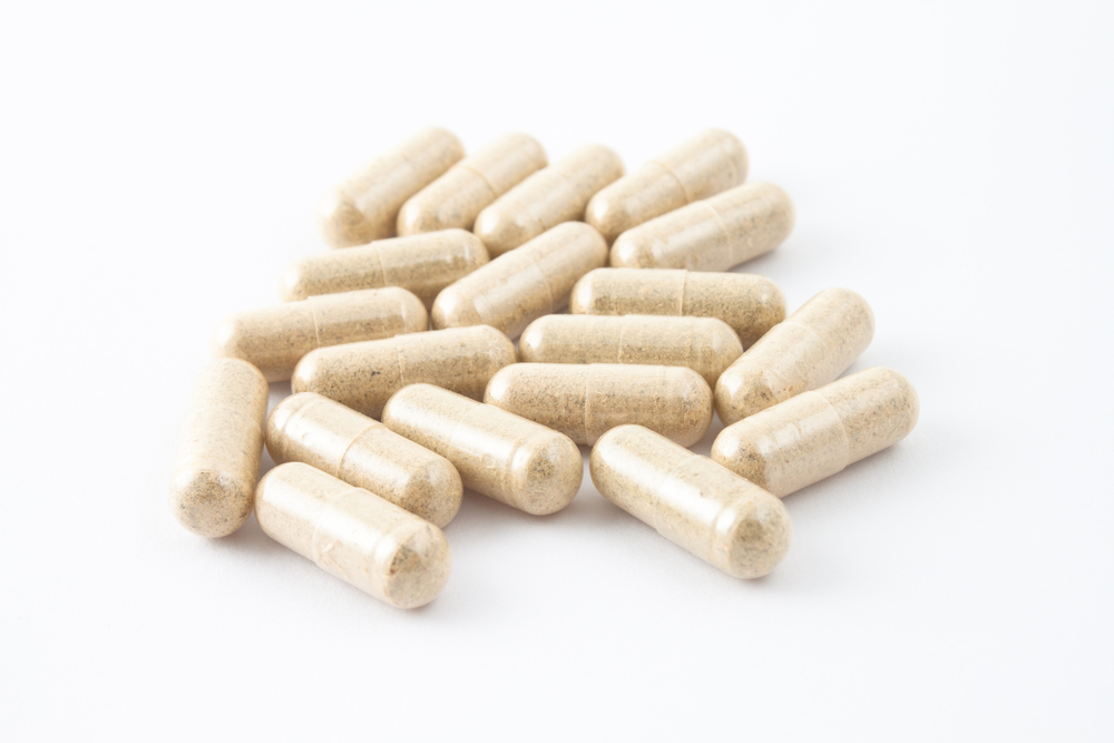 Pile of capsule medicine on white backgroundA